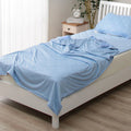 Blue lightweight cooling blanket on a bed