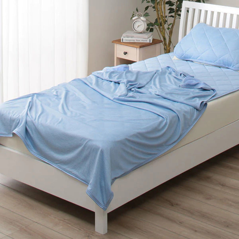 Blue lightweight cooling blanket on a bed