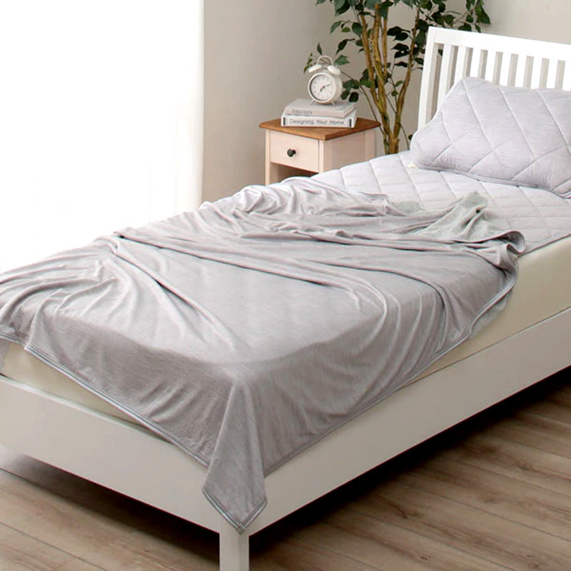 Grey lightweight cooling blanket on a bed
